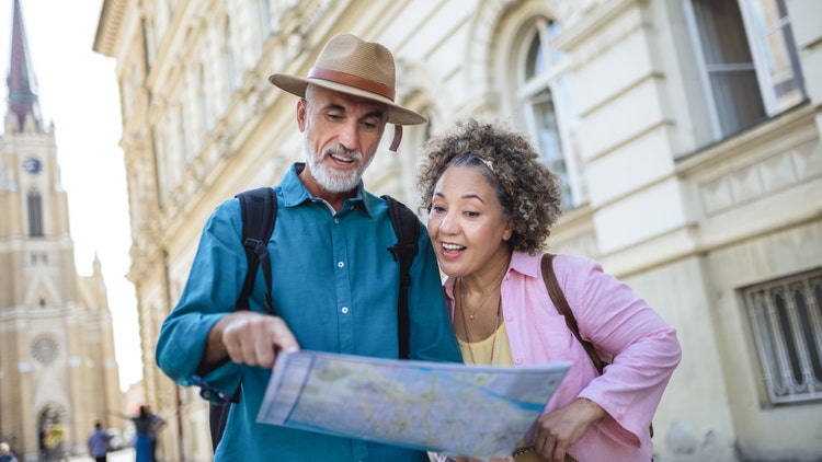An older man and woman looking at a map together outdoors