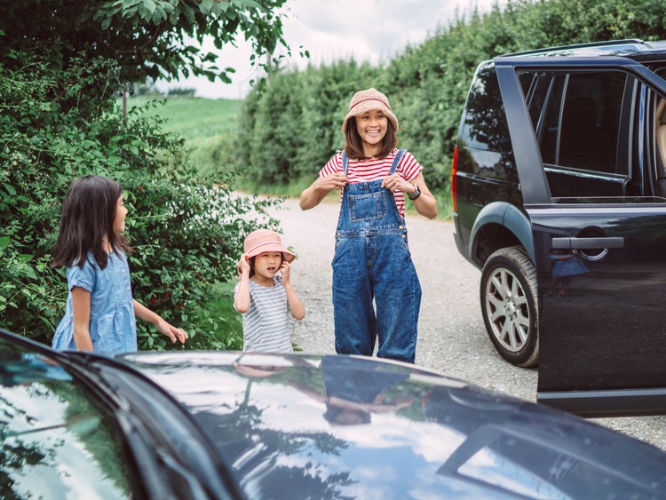 woman in overalls with young daughter outside