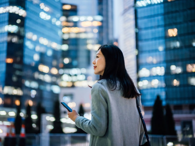Woman in a city holding cell phone