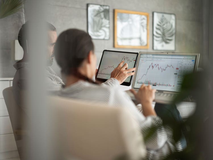 Man and woman at home looking at ETF values on computer