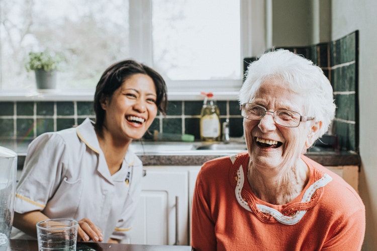 Two woman sit together, smiling