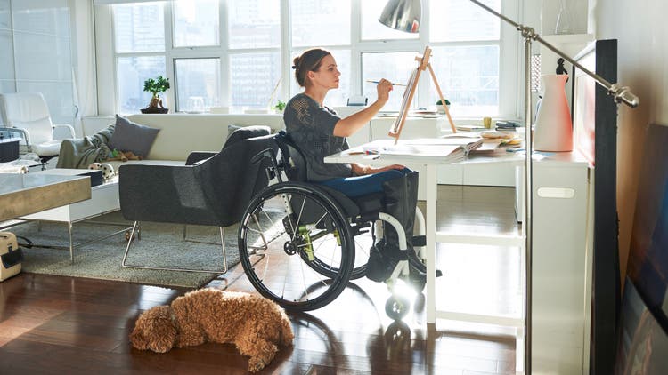 A woman in a wheel chair paints